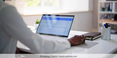 Mann tätigt Online-Überweisung an Laptop.