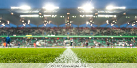 Blick auf ein Fußballspiel im Stadion abends bei Flutlicht.