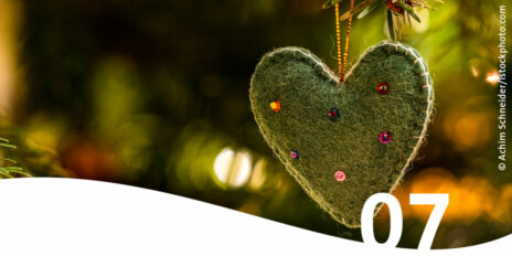 Weihnachtsbaumanhänger grünes Filzherz mit bunten Perlen im Vordergrund die Zahl 7