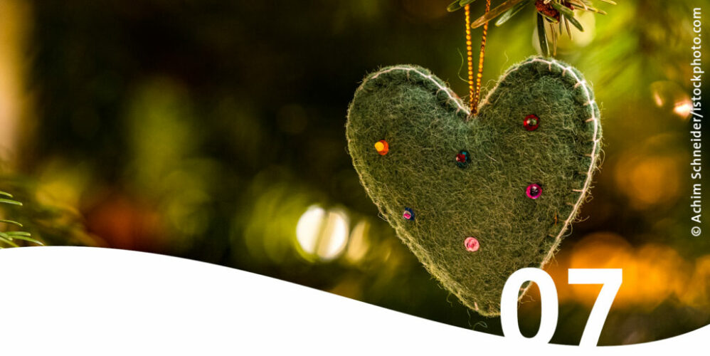 Weihnachtsbaumanhänger grünes Filzherz mit bunten Perlen im Vordergrund die Zahl 7