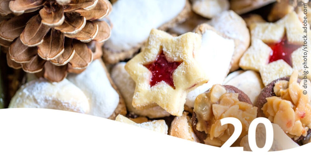 Weihnachtskekse und Tannenzapfen im Vordergrund die Zahl 20