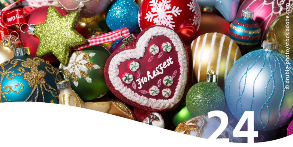 Nahaufnahme bunte Weihnachtskugeln mit Schriftzug Frohes Fest im Vordergrund die Zahl 24
