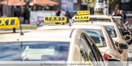 Mehrere Taxen parken hintereinander an einem Taxistand.