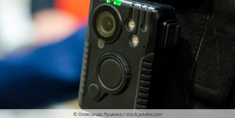 Bodycam, die an Hemdtasche einer Person befestigt ist.