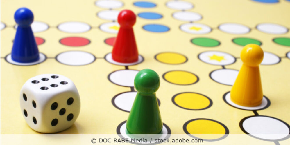 Mensch ärgere dich nicht Spielbrett mit Spielfiguren und Würfel.