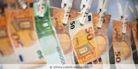 50 Euro und 100 Euro Banknoten hängen auf einer Wäscheleine als Symbol für Geldwäsche.