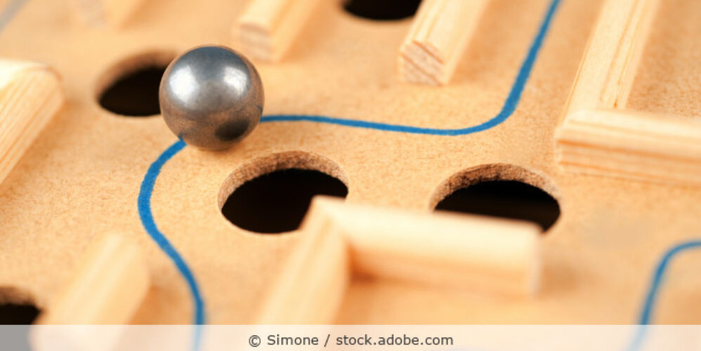 Detailansicht eines Geduldspiels aus Holz, bei dem eine Kugel durch eine Labyrinth balanciert wird.