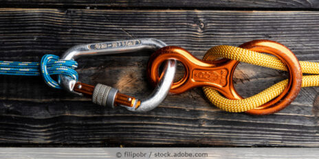 Kletterkarabiner und Abseilacht auf einem Tisch