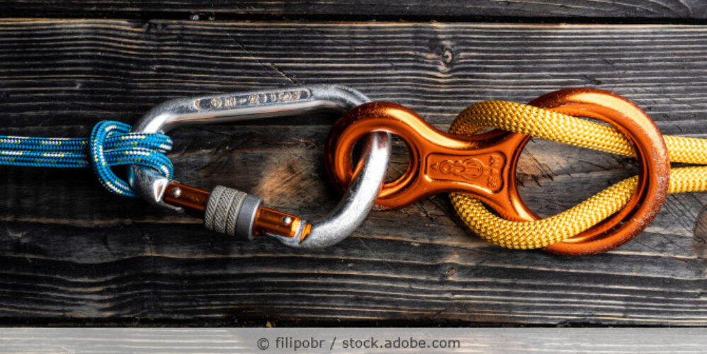 Kletterkarabiner und Abseilacht auf einem Tisch