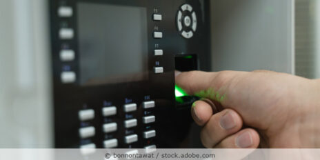 Hand an einem Fingerabdruckscanner zur Zutrittskontrolle.