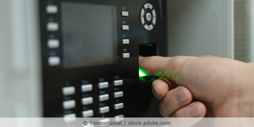 Hand an einem Fingerabdruckscanner zur Zutrittskontrolle.